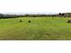 Picturesque land with hay bales dotting the expansive green field, perfect for agriculture or recreation at 1 Deer Run Trl, Hillsborough, NC 27278