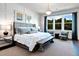 Bright main bedroom featuring a large window, pendant lighting, sitting area, and board and batten accent wall at 1 Deer Run Trl, Hillsborough, NC 27278