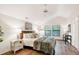 Bedroom featuring wood floors, vaulted ceiling, fan, and views of lush greenery at 101 Creekview Cir, Carrboro, NC 27510