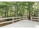 An expansive white deck is surrounded by trees offering a private outdoor space at 101 Creekview Cir, Carrboro, NC 27510