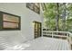 A rear exterior view highlighting a spacious deck with white railings surrounded by lush greenery at 101 Creekview Cir, Carrboro, NC 27510