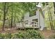 Rear exterior view of home surrounded by lush trees, with a white deck and green trim at 101 Creekview Cir, Carrboro, NC 27510