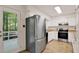 Stainless steel refrigerator and white cabinetry kitchen with door leading to porch at 101 Creekview Cir, Carrboro, NC 27510