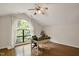 Office space with hardwood floors, desk, and a large arched window overlooking trees at 101 Creekview Cir, Carrboro, NC 27510