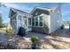 Back exterior showcases a charming home with a sunroom, stone patio, and beautifully landscaped backyard at 1013 Chelsea Run Ln, Apex, NC 27502