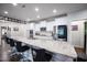 Modern kitchen island featuring white cabinets, granite countertops, designer bar stools, and stainless steel appliances at 1013 Chelsea Run Ln, Apex, NC 27502