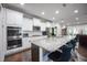 Bright kitchen with white cabinets, granite countertops, stainless steel appliances and large island with seating at 1013 Chelsea Run Ln, Apex, NC 27502
