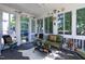 Bright sunroom with lots of windows, cozy seating and stylish decor to enjoy year-round natural light and comfort at 1013 Chelsea Run Ln, Apex, NC 27502