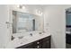 Bathroom featuring double sinks, a large mirror, vanity lighting and dark wood cabinets at 105 Chandon Dr, Princeton, NC 27569
