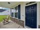 Inviting front porch with rocking chair, brick accents, and a dark blue front door at 105 Chandon Dr, Princeton, NC 27569