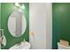 Stylish powder room with vibrant green walls, unique mirror, and modern fixtures at 105 Chandon Dr, Princeton, NC 27569