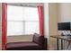 Cozy bedroom features a chaise lounge, large window with privacy blinds and curtains, and a desk at 11 Grifton Pl, Durham, NC 27704