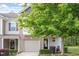 Inviting townhouse with an attached garage, manicured lawn, and mature shade tree at 11 Grifton Pl, Durham, NC 27704