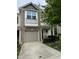 A two-story townhome featuring a one-car garage, brick accents and balcony window at 11 Grifton Pl, Durham, NC 27704