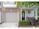 Attractive townhouse with an attached garage, a cozy front porch seating area, and manicured shrubs at 11 Grifton Pl, Durham, NC 27704