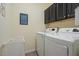 Efficient laundry room with white washer and dryer, upper cabinets, and convenient laundry guide at 11 Grifton Pl, Durham, NC 27704