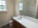 Bright bathroom featuring a vanity, toilet, tub and shower, and a window for natural light at 111 Shadow Bend Ln, Selma, NC 27576
