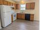 Functional kitchen with white appliances, wood cabinets, and updated flooring at 111 Shadow Bend Ln, Selma, NC 27576