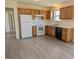 Functional kitchen with white appliances, wood cabinets, and updated flooring at 111 Shadow Bend Ln, Selma, NC 27576