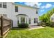 A sunny backyard features a wood fence, green grass, a door, bay window, and nice patio at 1121 Silky Dogwood Trl, Apex, NC 27502