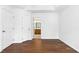This bedroom features white walls, hardwood floors and a view into the bathroom at 1121 Silky Dogwood Trl, Apex, NC 27502