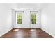Spacious bedroom features hardwood floors, white walls, and two windows at 1121 Silky Dogwood Trl, Apex, NC 27502