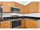 Updated kitchen boasts stainless steel appliances, light wood cabinets, and elegant granite countertops at 1121 Silky Dogwood Trl, Apex, NC 27502