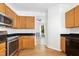 Well-lit kitchen features wood cabinets, stainless steel appliances, and black countertops at 1121 Silky Dogwood Trl, Apex, NC 27502