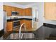 Modern kitchen with stainless appliances, light wood cabinets, and a double sink overlooking a backyard view at 1121 Silky Dogwood Trl, Apex, NC 27502