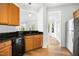 Well-lit kitchen features granite countertops, wood cabinets, and modern stainless steel appliances at 1121 Silky Dogwood Trl, Apex, NC 27502