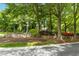 The Dogwood Ridge neighborhood entrance sign is made of stone and surrounded by trees and flowers at 1121 Silky Dogwood Trl, Apex, NC 27502
