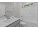 Bright bathroom featuring a shower-over-tub setup, white tile, and a large vanity with modern fixtures at 118 Chanute Cir, Louisburg, NC 27549