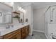 Bathroom featuring double vanity, wood cabinets, decorative mirrors, and a glass door shower at 118 Chanute Cir, Louisburg, NC 27549