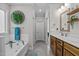 Well-lit bathroom featuring a vanity with wood cabinets, soaking tub and towel rack at 118 Chanute Cir, Louisburg, NC 27549
