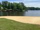 Picturesque beach view with calm water, sandy shore, and lush green grass, creating a relaxing and inviting atmosphere at 118 Chanute Cir, Louisburg, NC 27549