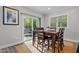 Sunlit dining area with wood table and seating adjacent to sliding doors with natural light at 118 Chanute Cir, Louisburg, NC 27549