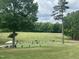 Picturesque driving range view, complete with benches, player, well-kept greens, and mature shade trees at 118 Chanute Cir, Louisburg, NC 27549