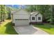 Charming white home featuring a two-car garage, manicured lawn, and traditional American flag at 118 Chanute Cir, Louisburg, NC 27549