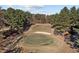 Beautiful golf course view featuring well-manicured greens, a sand trap, and mature trees on a sunny day at 118 Chanute Cir, Louisburg, NC 27549