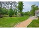Expansive backyard with gravel pathway, lush lawn, and inviting patio furniture overlooking a scenic lake at 118 Duncansby Ct, Cary, NC 27511