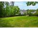 Spacious backyard with lush green lawn and mature trees, showcasing a beautiful home and landscaping at 118 Duncansby Ct, Cary, NC 27511