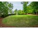 Lush backyard with a manicured lawn and trimmed hedges, complemented by mature trees at 118 Duncansby Ct, Cary, NC 27511