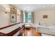 Bright bathroom boasts wood floors, marble vanity, and soaking tub for a relaxing experience at 118 Duncansby Ct, Cary, NC 27511