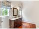 Elegant bathroom with dark wood vanity, marble countertop, and decorative mirror with natural light at 118 Duncansby Ct, Cary, NC 27511
