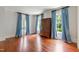 Spacious bedroom with hardwood floors, natural light, and elegant window treatments at 118 Duncansby Ct, Cary, NC 27511