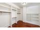 Spacious walk-in closet with white shelving and hardwood floors at 118 Duncansby Ct, Cary, NC 27511