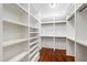 Spacious walk-in closet featuring built-in shelving, wood floors, and ample storage space at 118 Duncansby Ct, Cary, NC 27511