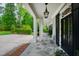 Home's covered porch with stone flooring, columns, and a white chair at 118 Duncansby Ct, Cary, NC 27511