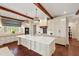 Elegant kitchen with white cabinetry, marble countertops, exposed beams, and modern appliances at 118 Duncansby Ct, Cary, NC 27511