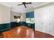 Spacious living room with wood floors, wainscoting, blue and white valences and a ceiling fan at 118 Duncansby Ct, Cary, NC 27511